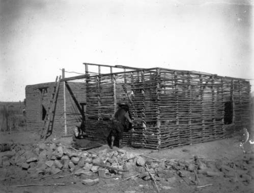 Fort Defiance - Native Americans (Navajo) build wood and adobe building