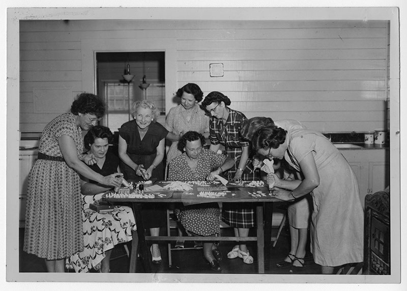 A group of women gathered around a table working on decorations, Manchester, Georgia, 1953